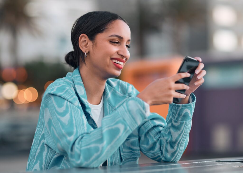 Happy woman holding a phone texting on social media, browsing internet or chatting on an instant, t